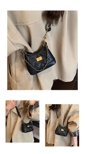 Detailed macro view of black quilted faux leather handbag with gold twist lock and chain strap