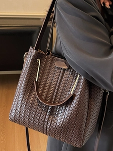 Minimalist dark brown woven leather bucket bag with top handle and shoulder strap
