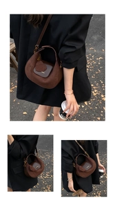 Detail of dark brown suede crescent bag with heart charm and gold hardware accents