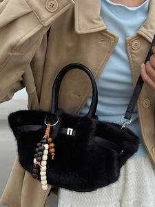 Chic black faux fur handbag with wooden bead charms and leather handles in stylish autumn look