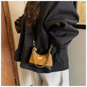 Detailed back view of a quilted suede shoulder bag in brown and black with chain strap