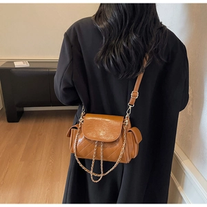 Detail view of brown vintage chain crossbody bag with diamond quilting and side pockets