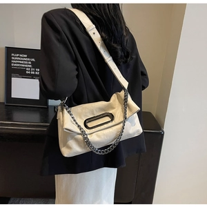 Detailed close-up of cream pleated leather bag with metal handle and gray chain