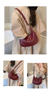 Detail view of burgundy woven hobo bag with adjustable strap and gold buckle