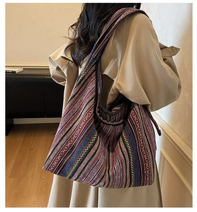 Close-up of bohemian oversized canvas tote with colorful ethnic stripes and wide shoulder strap