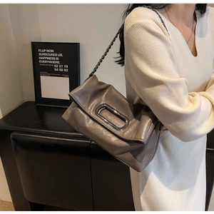 Detail of grey leather pillow bag with stylish silver metal buckle and chain strap