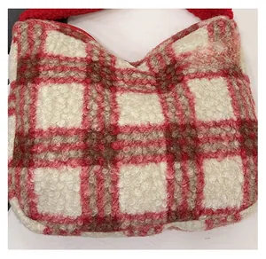 Close-up of soft red and white plaid fleece fabric and fuzzy handle of a shoulder bag