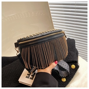 Detail view of black quilted leather crossbody bag with gold rivet studs and chain tassels