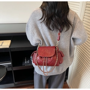Detailed shot of vintage red quilted handbag with golden chain strap and leather texture