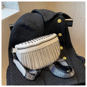 Detail of silver studs and long metal fringe on white faux leather belt bag