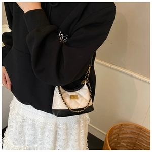 Detail of quilted mini hobo bag with gold square buckle and metal chain strap