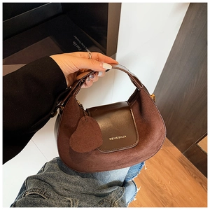 Detail of vintage crescent handbag featuring brown suede and smooth leather stitching