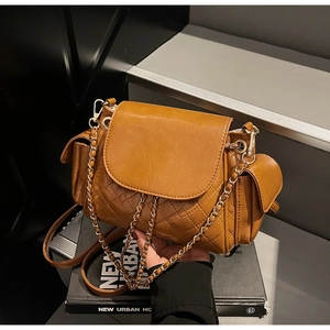Detail of caramel brown quilted leather bag with side pockets and chain strap