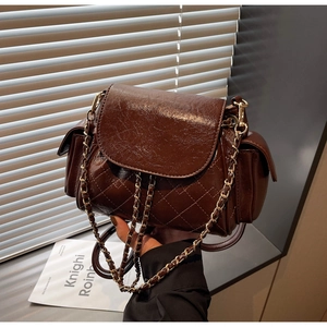Detailed view of dark brown quilted leather texture and metallic chain strap