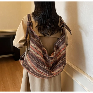 Detailed back view of a large bohemian striped canvas tote bag with knotted shoulder strap