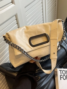 French retro cream white pillow bag with chain and wide strap on leather sofa