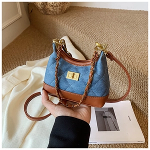 Detail of denim crossbody bag featuring classic quilting and gold twist-lock closure