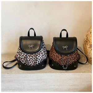 Vue détaillée des mini sacs à dos léopard avec nœud métallique et bordure en dentelle