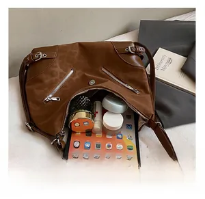 Detail showing spacious interior of brown tote bag with tablet and cosmetics