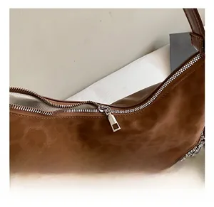 Detailed close-up of brown leopard-patterned tote with silver zipper and woven lining