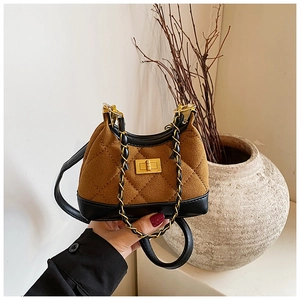 Detail of vintage suede crossbody bag with brown quilting and black leather base
