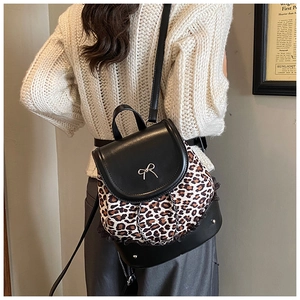 Détail d'un sac à dos léopard avec nœud papillon argenté et bordure en dentelle noire