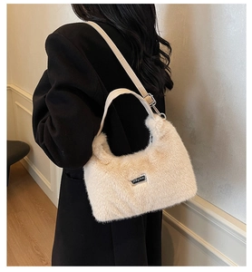 Detail of soft beige faux fur texture with high-quality metal logo plate on small handbag