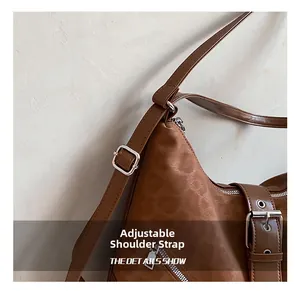 Detail of adjustable shoulder strap with silver metal buckle on brown tote bag