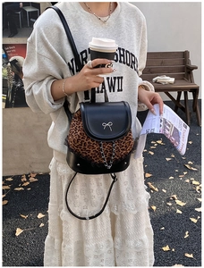 Détail du sac à dos léopard avec un nœud en métal argenté et une chaîne décorative