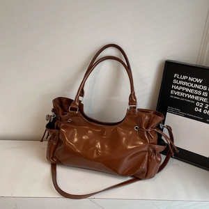 Detail of dark brown wax leather shoulder bag featuring drawstring design and silver hardware