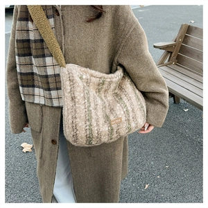 Close-up of beige plaid knit tote bag with green stripes and cozy fleece shoulder strap