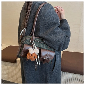 Detail of vintage green plaid tweed Boston bag with brown leather and teddy bear charm