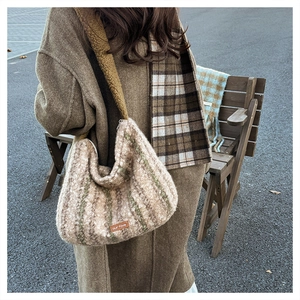 Detail of wool texture underarm bag with plaid stripes and cozy lamb wool shoulder strap