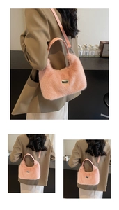 Detail of pink faux fur crossbody bag featuring soft plush texture and a metal logo plaque