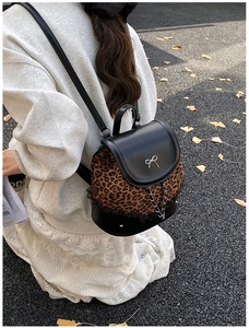 Détail du mini sac à dos à imprimé léopard avec nœud en métal argenté et chaîne