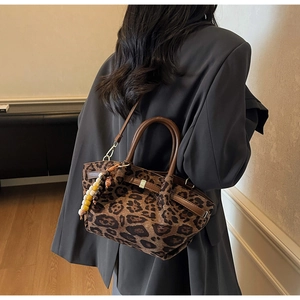 Detailansicht der Wildledertasche mit Leopardenmuster, Ledergriffen und Perlenanhänger