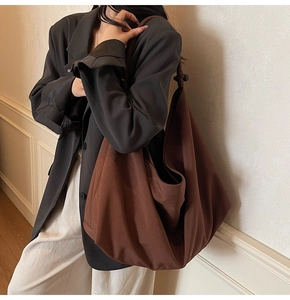 Detail einer großen braunen Segeltuch-Hobo-Tasche mit dekorativem Schultergurt-Knoten