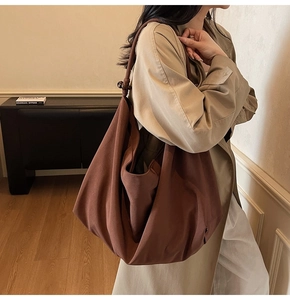 Detailansicht der großen braunen Canvas-Hobo-Tasche mit Vintage-Holzperlen am Schultergurt