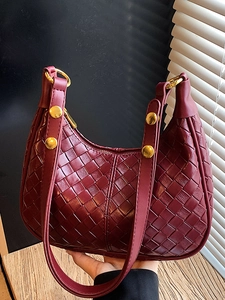 Elegant wine red woven crescent shoulder bag with metallic gold hardware details