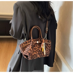 Detailansicht der Canvas-Tasche mit Leopardenmuster, Lederriemen und bunter Perlenkette