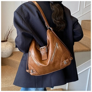 Detailed view of brown vintage leather tote bag with silver metal zips and buckles