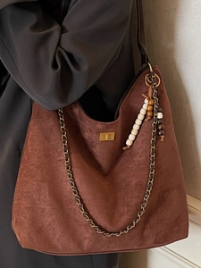 Sac hobo en daim marron avec boucle dorée, bandoulière chaîne et pompon en perles