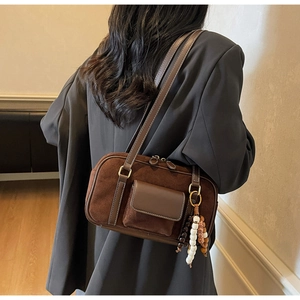 Brown frosted suede Boston bag styled over the shoulder on a dark grey blazer