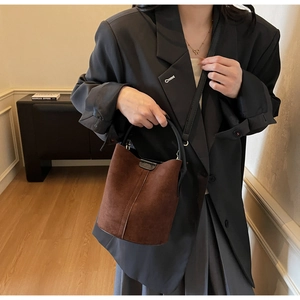 Brown matte suede bucket bag shown in lifestyle scene with model for daily commute style