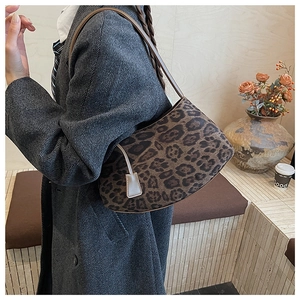 Détail du sac hobo à motif léopard avec bandoulière en cuir dans un café rétro élégant