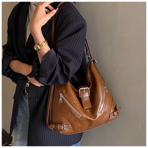 Detail of vintage brown Hobo bag with silver buckles and zippers on casual suit