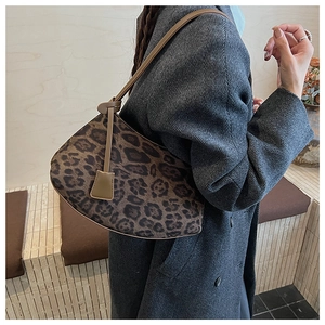 Détail d'un sac à bandoulière vintage léopard en forme de croissant porté par un mannequin