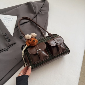 Detail view of retro plaid Boston bag with leather pockets and plush dog charm