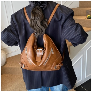 Detail of vintage brown shoulder bag with silver buckle and functional side zippers