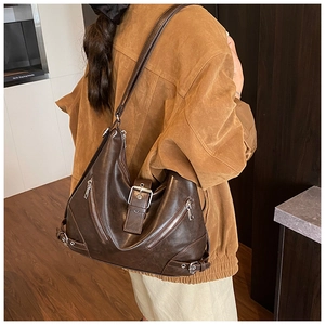 Detail view of brown hobo tote with oil wax leather texture and side zipper accents